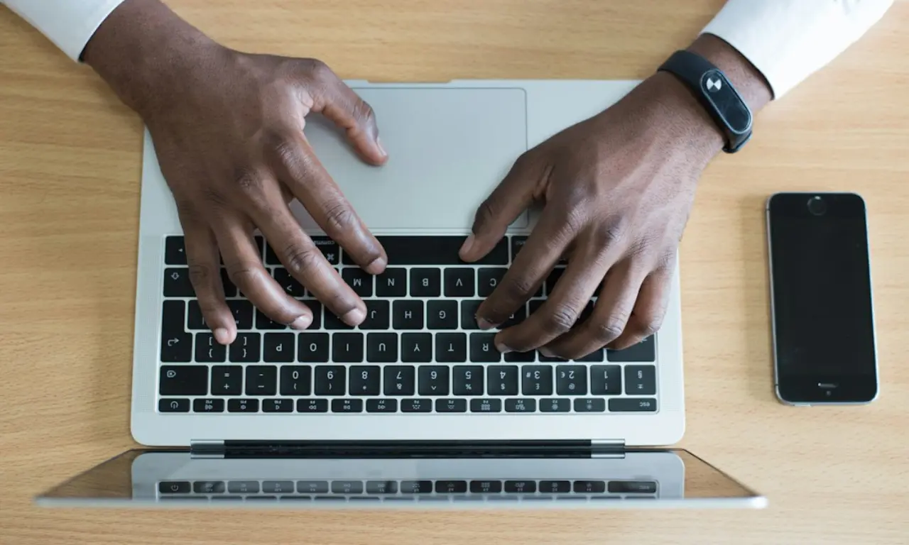 Person typing on a laptop, with the screen showing an email capture form asking for user details and a 'Sign Up' button.