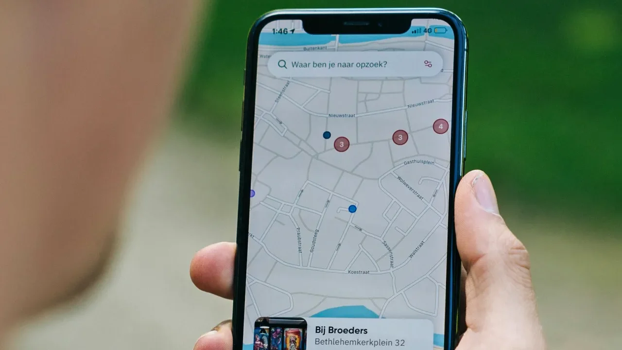 A person holding iPhone with Google Maps open on it.